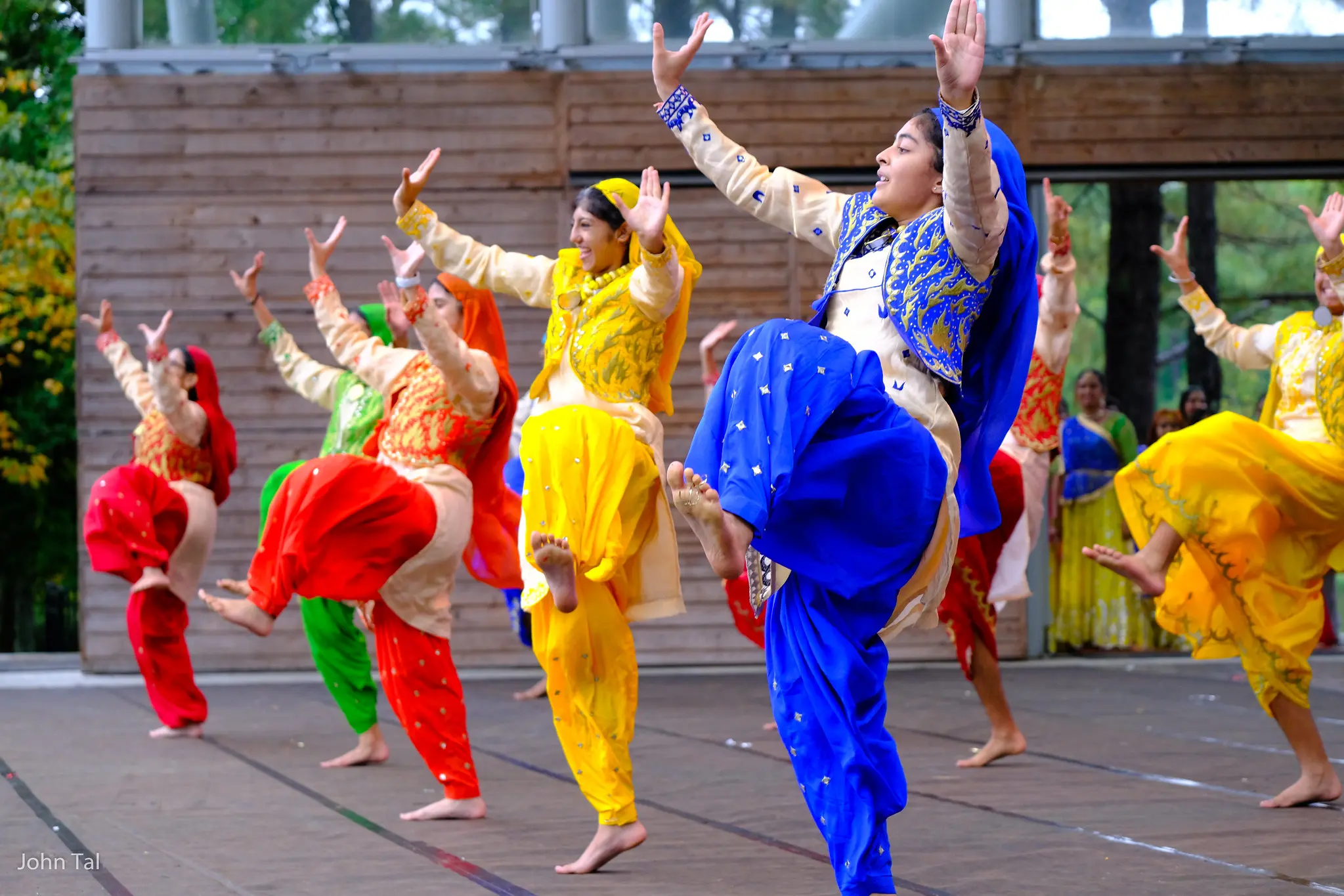 Indian performers in colorful attire dancing on stage