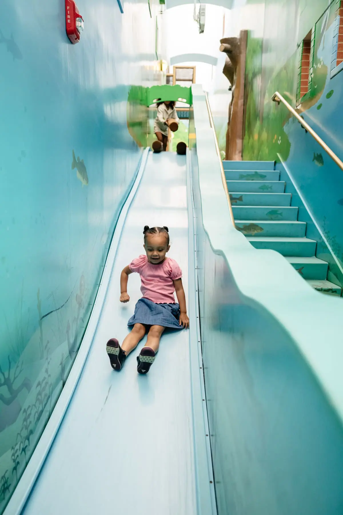A girl sliding down a slide.